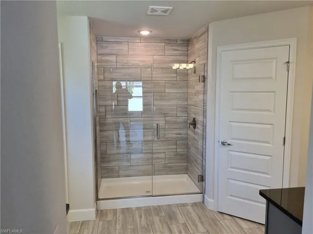 Bathroom featuring vanity and a shower with shower door