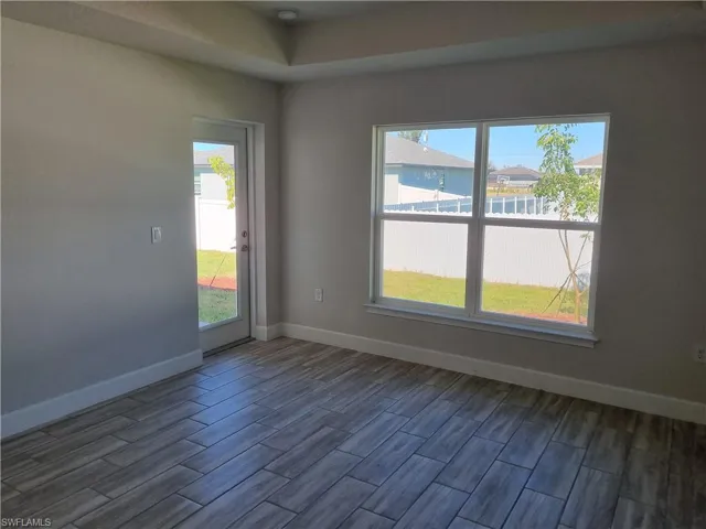 Spare room with dark hardwood / wood-style flooring