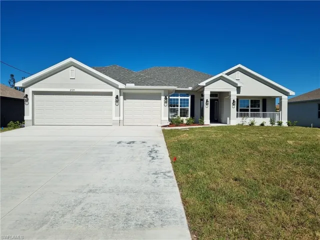View of front of house featuring a front yard, a porch, and a garage