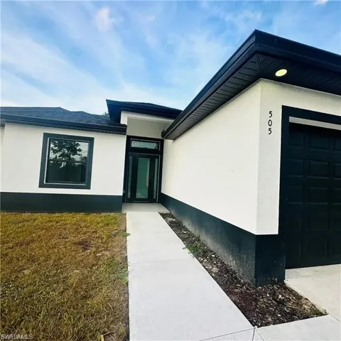 Modern exterior featuring a white stucco facade with black trim accents