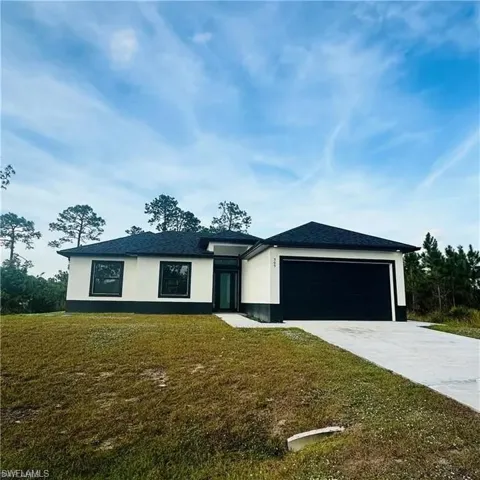 Contemporary single-story home featuring a stucco exterior, dark shingle roof, and a black garage door