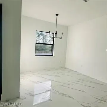 Spacious interior featuring large format tile flooring, a black-framed window, a black modern chandelier, and neutral wall tones