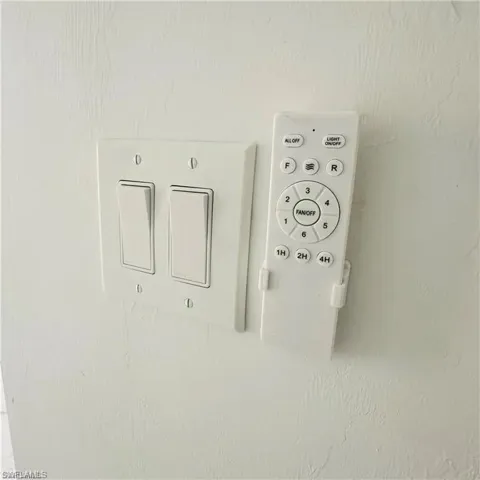 Wall-mounted controls featuring dual rocker light switches and a remote in a wall-mounted holster