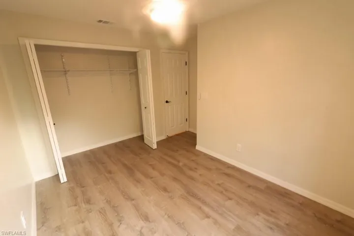 Unfurnished bedroom with light hardwood / wood-style flooring and a closet