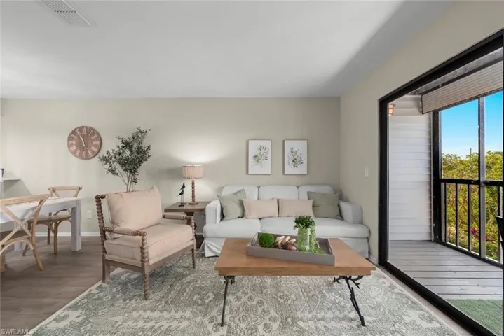 Living room with visible vents, baseboards, and wood finished floors