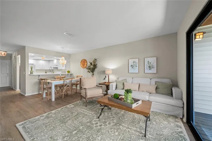Living area featuring baseboards, visible vents, and wood finished floors