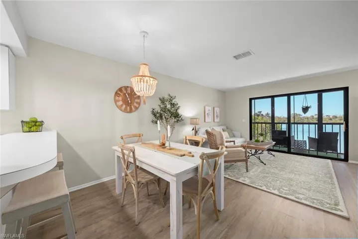 Dining space featuring wood finished floors, a notable chandelier, baseboards, and visible vents
