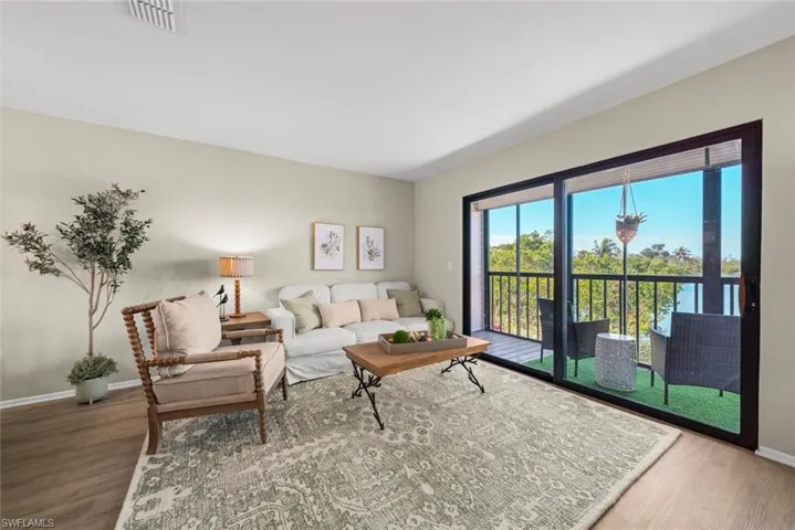 Living room featuring baseboards, visible vents, and wood finished floors