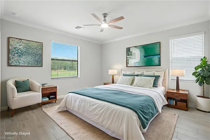Bedroom featuring ornamental molding, light wood-style flooring, and a ceiling fan