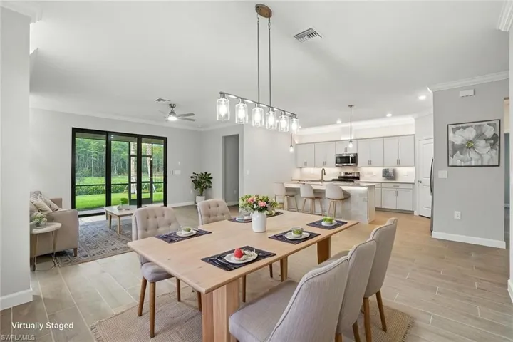 Dining area featuring ornamental molding, wood finish floors, a ceiling fan, and recessed lighting