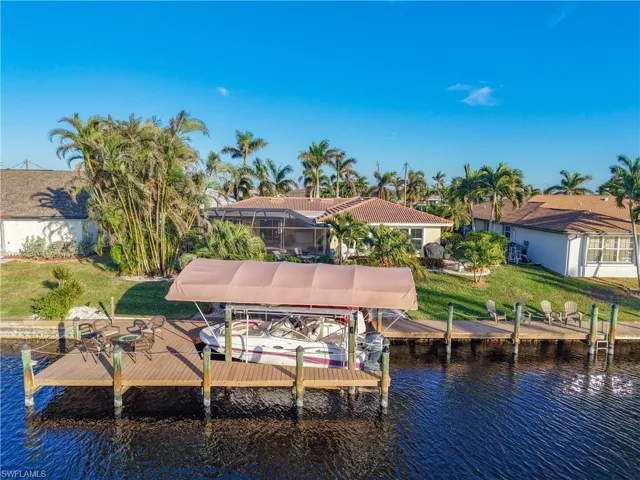 View of dock with a lawn, a water view, and a lanai