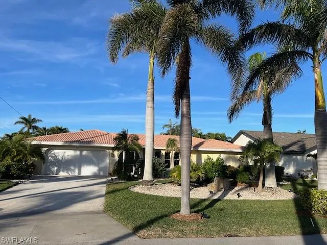 View of front facade featuring a garage and a front lawn