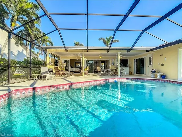 View of swimming pool with a patio, ceiling fan, and a lanai