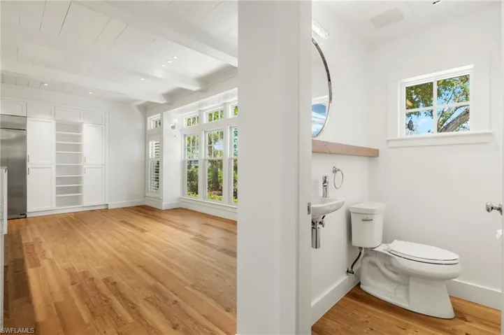 Half Bathroom featuring light wood finished floors and beamed ceiling