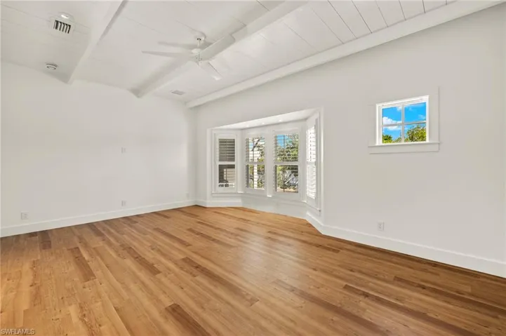 Primary bedroom  with light wood-style flooring, a ceiling fan, and a wooden ceiling with exposed beams