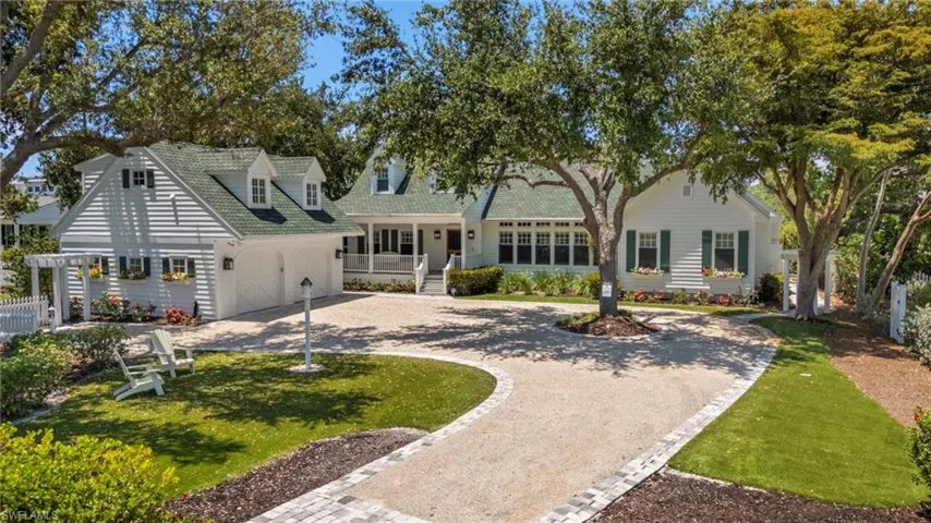 Front view of property featuring curved driveway and a porch