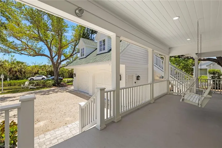 Covered front porch with a garage and stairs