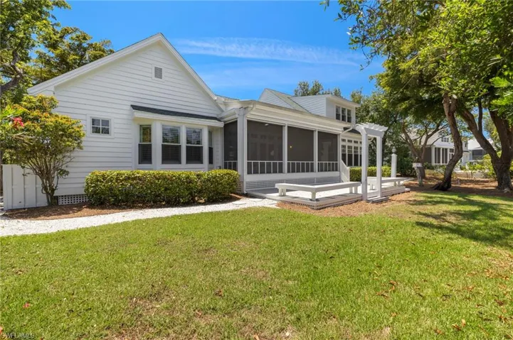 Back of property featuring a sunroom and a lawn