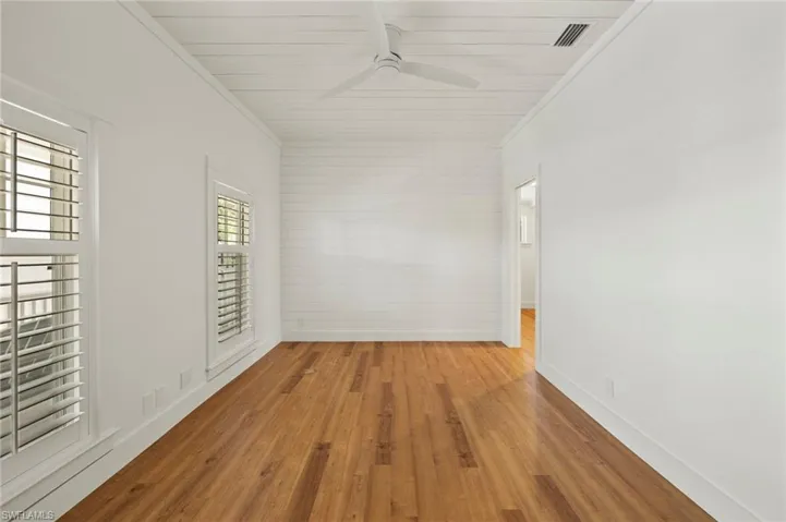 Den/Office with wood finished floors, crown molding, and a ceiling fan