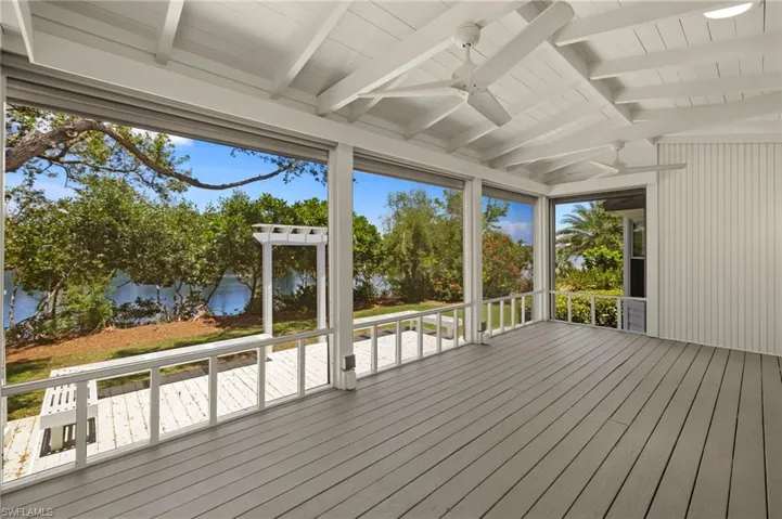 Deck with a ceiling fan, a water view, and a sunroom