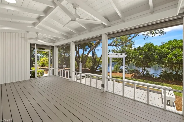 Unfurnished sunroom with a ceiling fan and a wooden deck