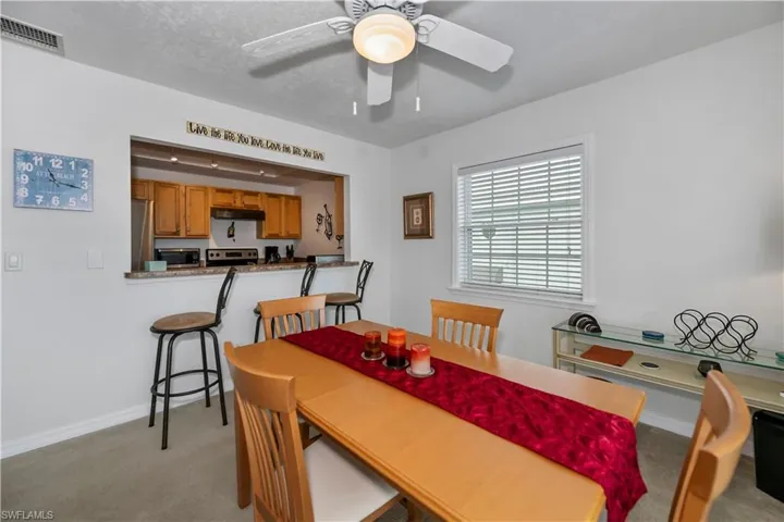 Dining room with light carpet, ceiling fan, and a textured ceiling
