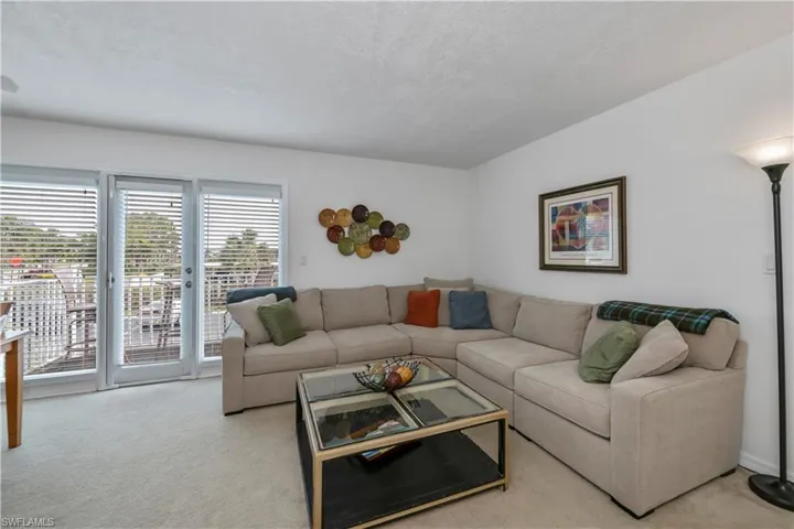 Living room featuring light colored carpet and a textured ceiling