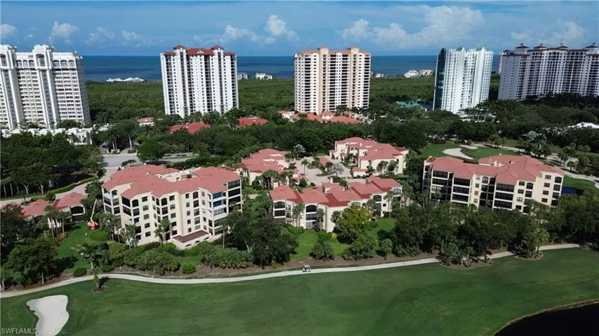 Aerial view of property and surrounding area with a local golf course and a large body of water