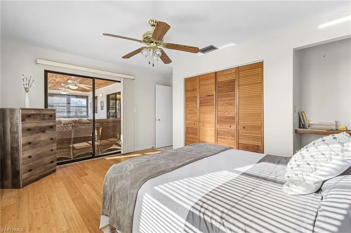 Bedroom with hardwood / wood-style flooring, a ceiling fan, access to outside, and a closet