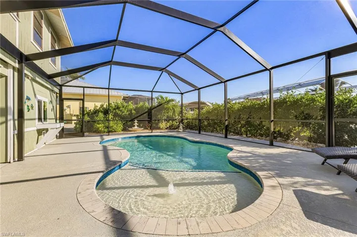 Swimming pool featuring screened enclosure, and a patio