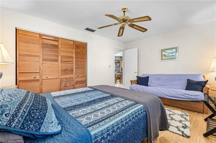 Bedroom featuring ceiling fan, wood finished floors, and a closet