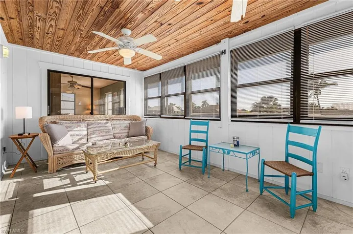 Sunroom / solarium featuring tile patterned floors, wooden ceiling, and wooden walls