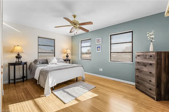 Bedroom featuring multiple windows, a ceiling fan, and light wood-type flooring