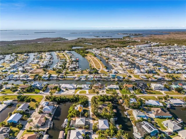 Aerial view of property's location with a large body of water and nearby suburban area