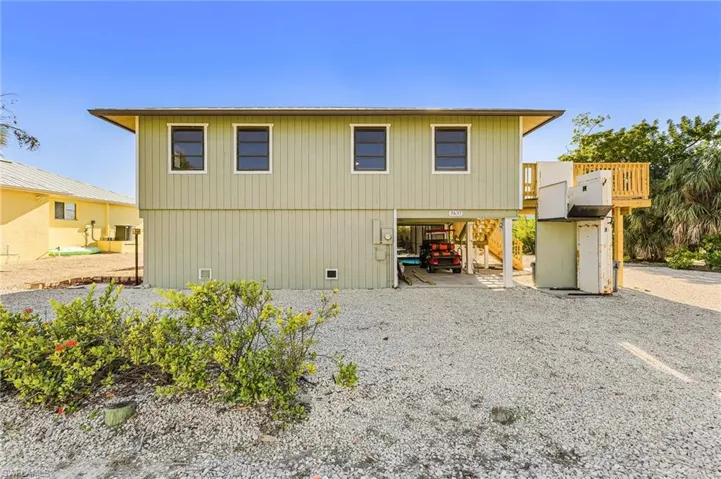 Front of house featuring a carport and gravel driveway