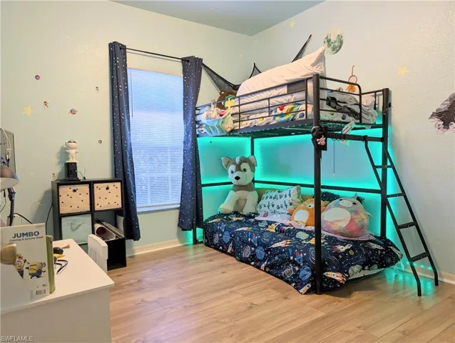 Bedroom with hardwood / wood-style flooring, ceiling fan and walk in closet.