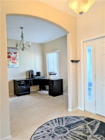 Tiled foyer entrance with a chandelier.