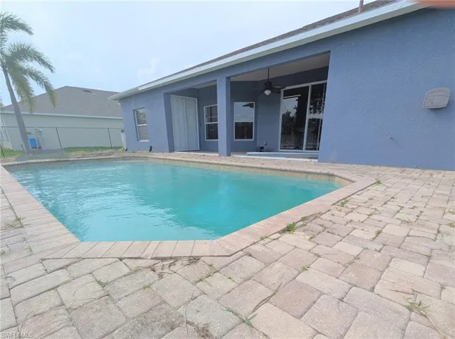 Pool featuring fence, ceiling fan, and a patio area