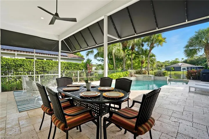 View of patio featuring ceiling fan, grilling area, and outdoor dining area