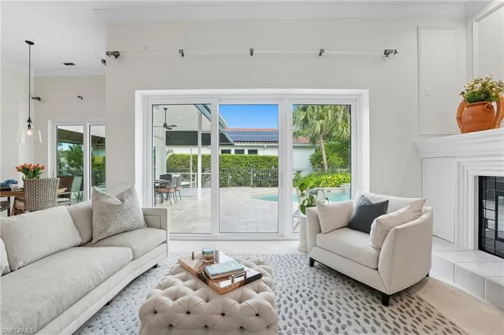 Carpeted living room with crown molding, a fireplace, and healthy amount of natural light