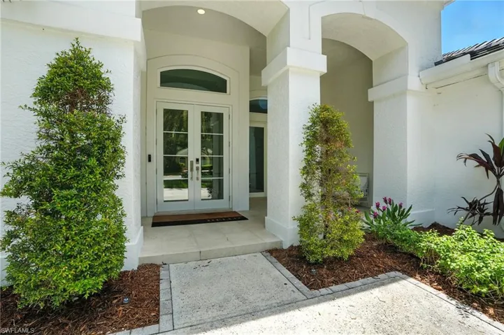 View of exterior entry with french doors and stucco siding