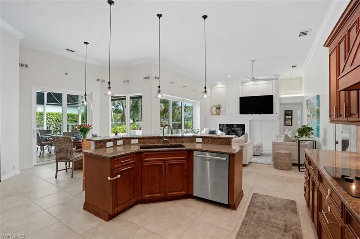 Kitchen featuring a ceiling fan, decorative light fixtures, stainless steel dishwasher, dark stone counters, and crown molding