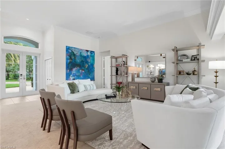 Living room with french doors, crown molding, and carpet flooring