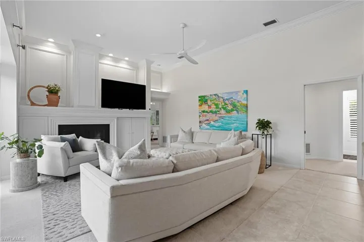 Living area with ceiling fan, crown molding, a fireplace, tile patterned flooring, and recessed lighting