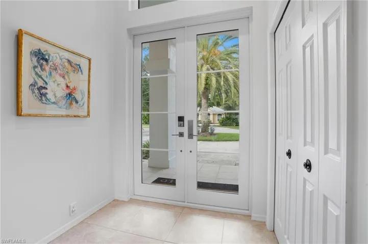 Doorway to outside featuring baseboards and tile patterned flooring