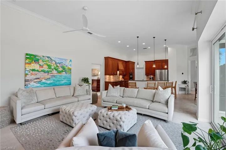 Living room with light colored carpet, ornamental molding, ceiling fan, and recessed lighting