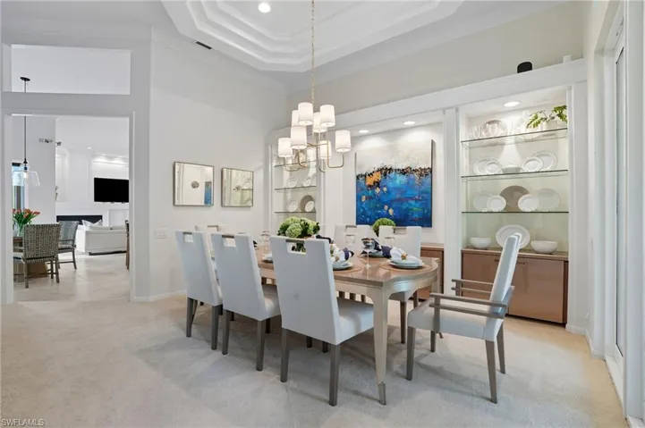 Dining area featuring light colored carpet, a chandelier, crown molding, and recessed lighting