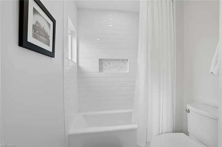 Full bathroom with shower / bath combo and toilet