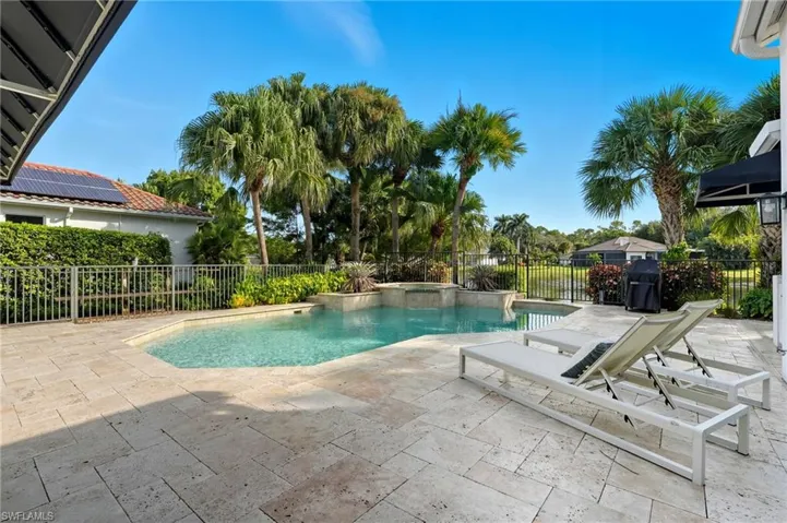 View of swimming pool with a patio area, a pool with connected hot tub, and a fenced backyard
