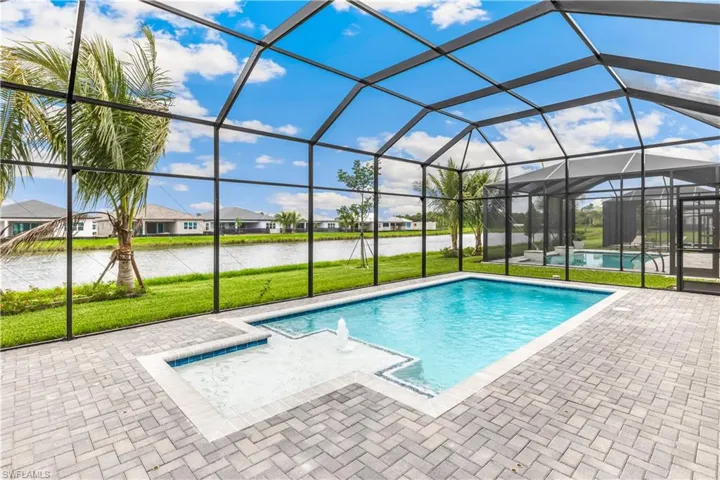 Enclosed Pool with sunshelf, bubbler, and view of lake